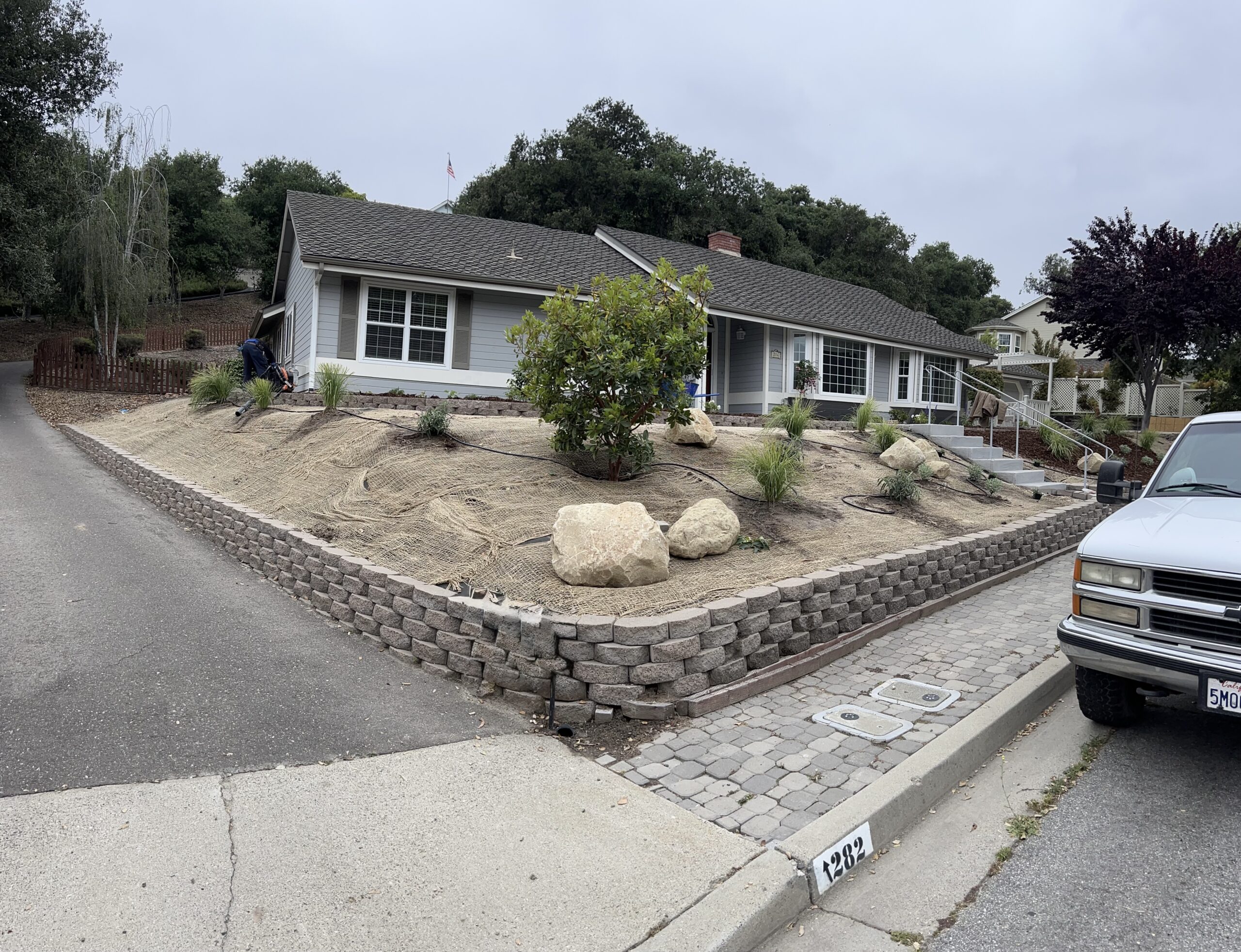 Block retaining wall with cobble apron